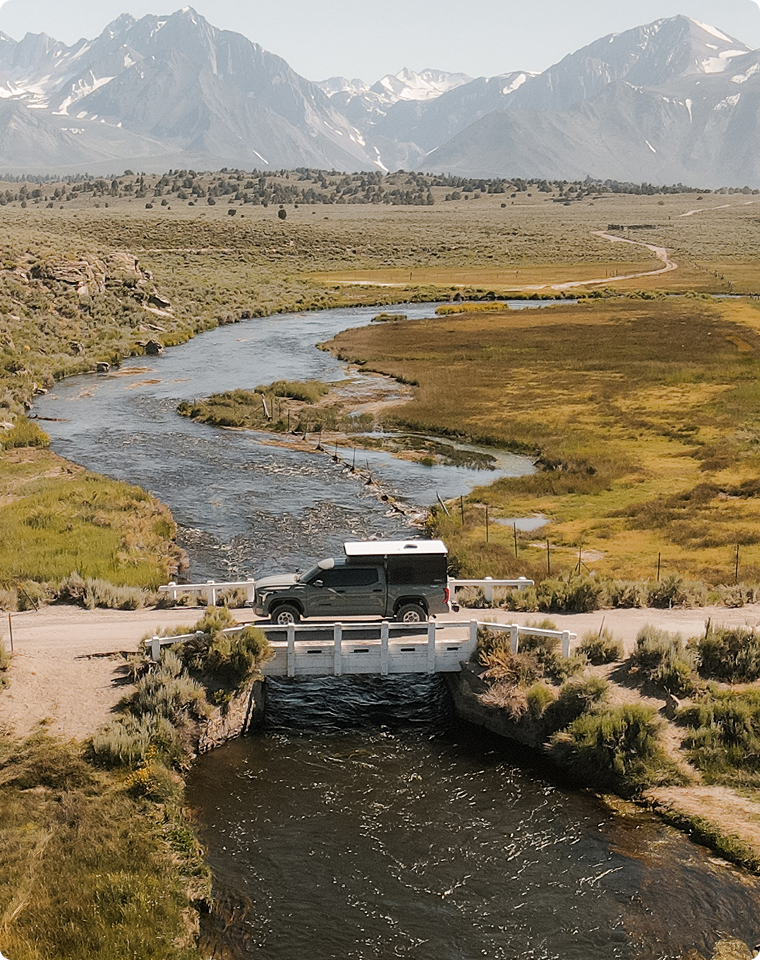 Gray Toyota Tundra on a bridge crossing a river